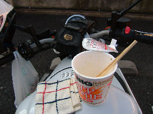 バイクにまたがってカップ麺